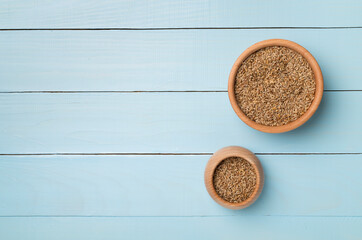 Wholegrain spelt farro in bowl on wooden background. Top view