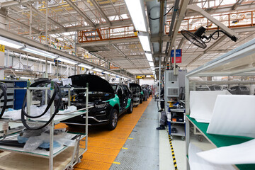 Car bodies are on assembly line. Factory for production of cars. Modern automotive industry. Electric car factory