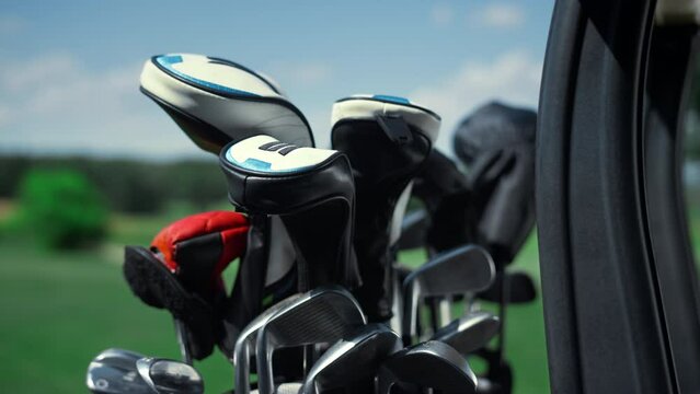 Professional sport golf clubs in bag outside. Putter equipment in golfing cart.