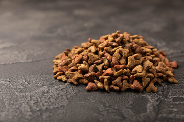 Dry food for cats on a cement background. Vitamins and nutrients for good health and energy of pets.Copy space.