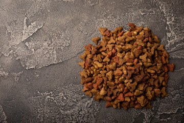 Dry food for cats on a cement background. Vitamins and nutrients for good health and energy of pets.Copy space.