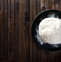 yeast dough for bread or pizza on a floured surface, with flour splash. Cooking bread.	