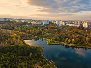 Fototapeta na wymiar Aerial view of a lake in a park with autumn trees. Kishinev, Moldova. Epic aerial flight over water. Colorful autumn trees in the daytime.