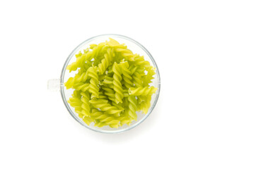 Close-up background of Fusille and Rotini in a glass bowl on white. pasta colorata	