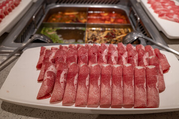 Selective focus view at slice of beef and pork beside mala hotpot and various type of soup. 