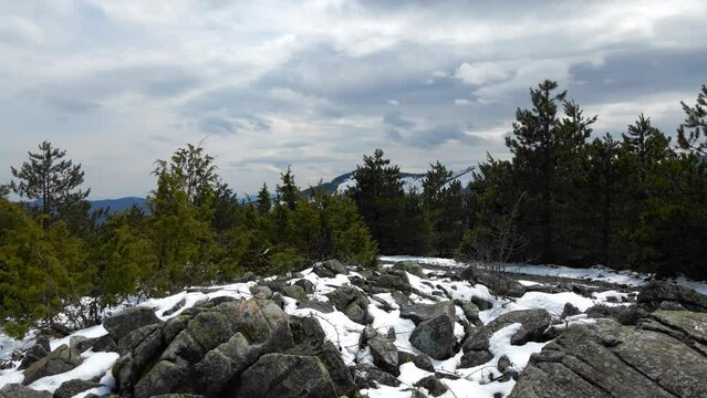 Aerial scenery of snowy mountains in spring Snow-capped Goc Mountain In Serbia spring landscape. Beautiful Shot Of Natural Rocks On Green Landscape During Sunny Day.