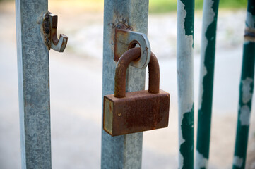 The gates are broken open and on one leaf there is a closed padlock.