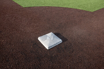 Top down, close up view of a base on a clean baseball field on a bright, sunny day