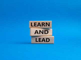Learn and lead symbol. Concept words 'Learn and lead' on wooden blocks. Beautiful blue background. Business and Learn and lead concept. Copy space.
