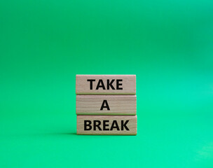 Take a break symbol. Concept words 'Take a break' on wooden blocks. Beautiful green background. Business and Take a break concept. Copy space.