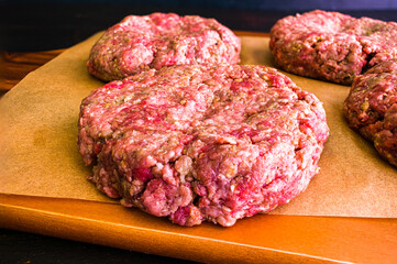Raw Hamburger Patty Seasoned with Pesto and Garlic: Closeup view of hand made burger patty with Italian seasonings