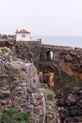 A small building on a cliff above the ocean next to Boca de Inferno