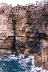Vibrant turquoise ocean waves crash against the rocks