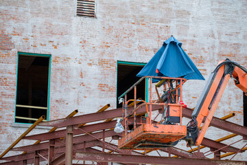 Fototapeta na wymiar Empty cherry picker lift with folded umbrella at construction site in New Orleans, LA, USA