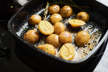 Close-up of delicious baby potatoes fried in grill pan with butter, rosemary and thyme