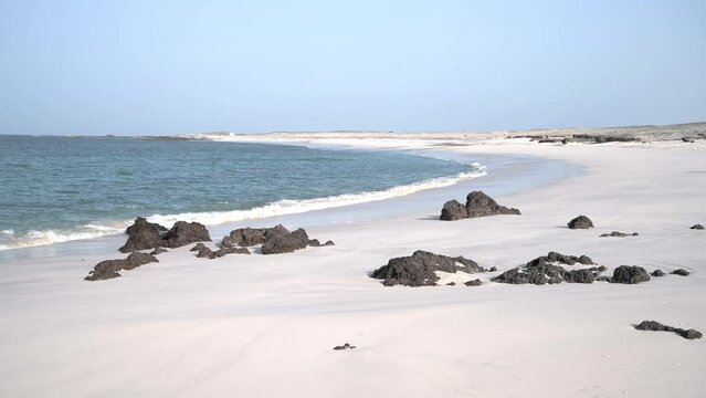 Idyllic beach of white sand with some rocks, Masirah Island, Sultanate of Oman, Middle East, Arabian Peninsula. 4k Footage real time