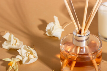 reed diffuser with flowers. Incense sticks for the home with a floral scent with hard shadows. The...