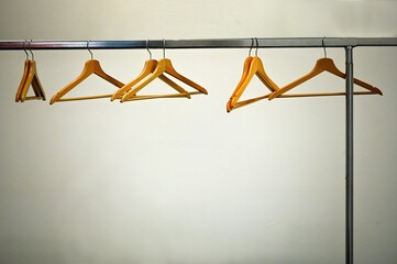 deserted cloakroom view with clothes rack and woodden hangers on white wall