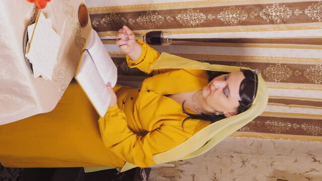 A female rabbi of the Reform Jewish community shaved bald in a kippah at the table preparing for the event. Vertical video