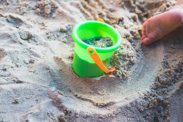 Toddler baby playing concept: Cut out of young boy playing in the sandbox, summer time