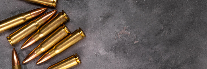 Bullets on gray background banner with copy space. Cartridges 7.62 caliber for Kalashnikov assault...