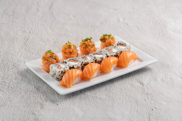 Fresh made sushi mix. Different kinks of salmon sushi served on white plate. Studio shoot on slated...