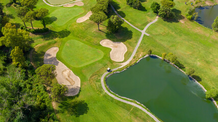 Aerial view of a golf course in the morning. There are no people on the putting green.