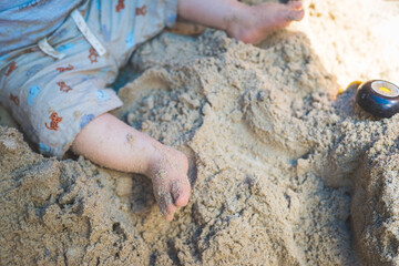 Toddler baby playing concept: Cut out of young boy playing in the sandbox, summer time