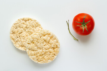 Rice cakes and tomato on white