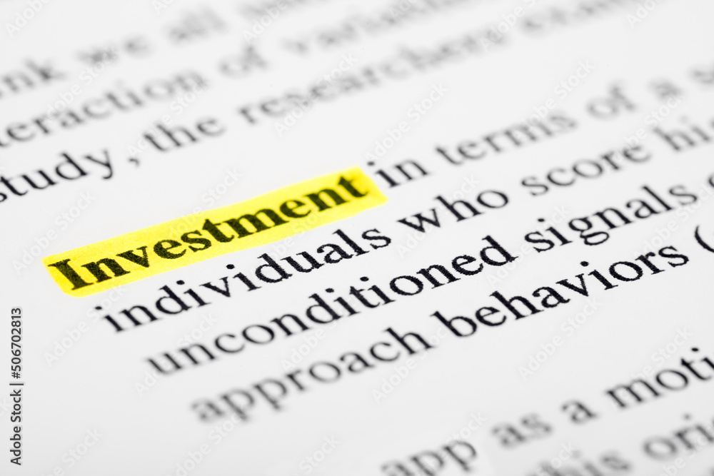 Poster investment text macro shot highlighted in yellow color on printed paper