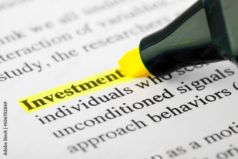 Fototapete investment text macro shot highlighted in yellow color on printed paper