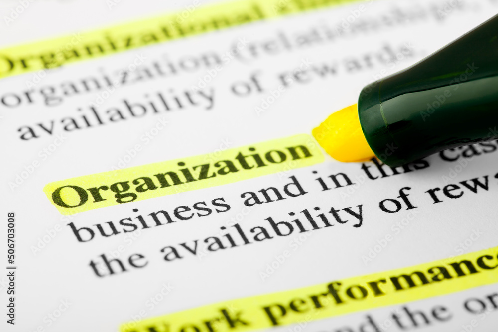 Fototapete organization text macro shot highlighted with a highlighter in yellow color on printed paper