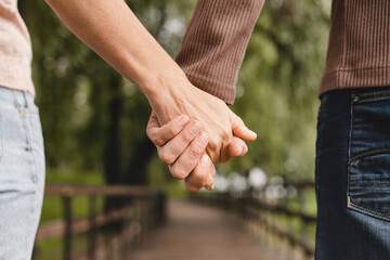 Cropped closeup photo of a mature heterosexual couple holding hands together while walking on a...