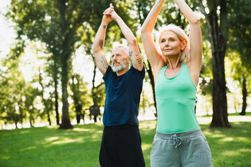Closeup cropped photo of mountain yoga pose position. Portrait of two mature people couple meditating practicing yoga outdoors on fitness mat together.