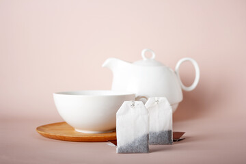 rectangular tea bags on the background of ceramic cups and teapot, copy space, selective focus