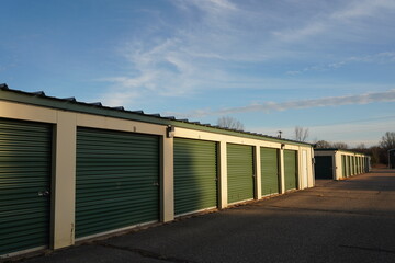 Fototapeta na wymiar Green and tan storage units service the community to hold the owner's property.