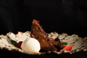 Chocolate brownie with strawberries and vanilla ice cream.