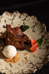 Chocolate brownie with strawberries and vanilla ice cream.