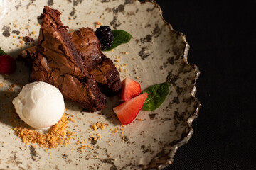 Chocolate brownie with strawberries and vanilla ice cream.