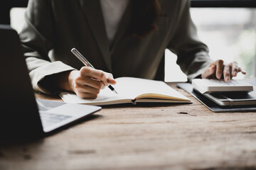 Businessman takes notes in a notebook, owns a startup company, sits in his office and checks the company's financial summary prepared by the finance department. Management concept of startup company.
