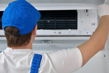 Quick cleaning and regulating home air conditioner worker inspects air conditioner. Procedure...