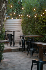 wooden bar with tables black metal chairs and yellow hanging lights