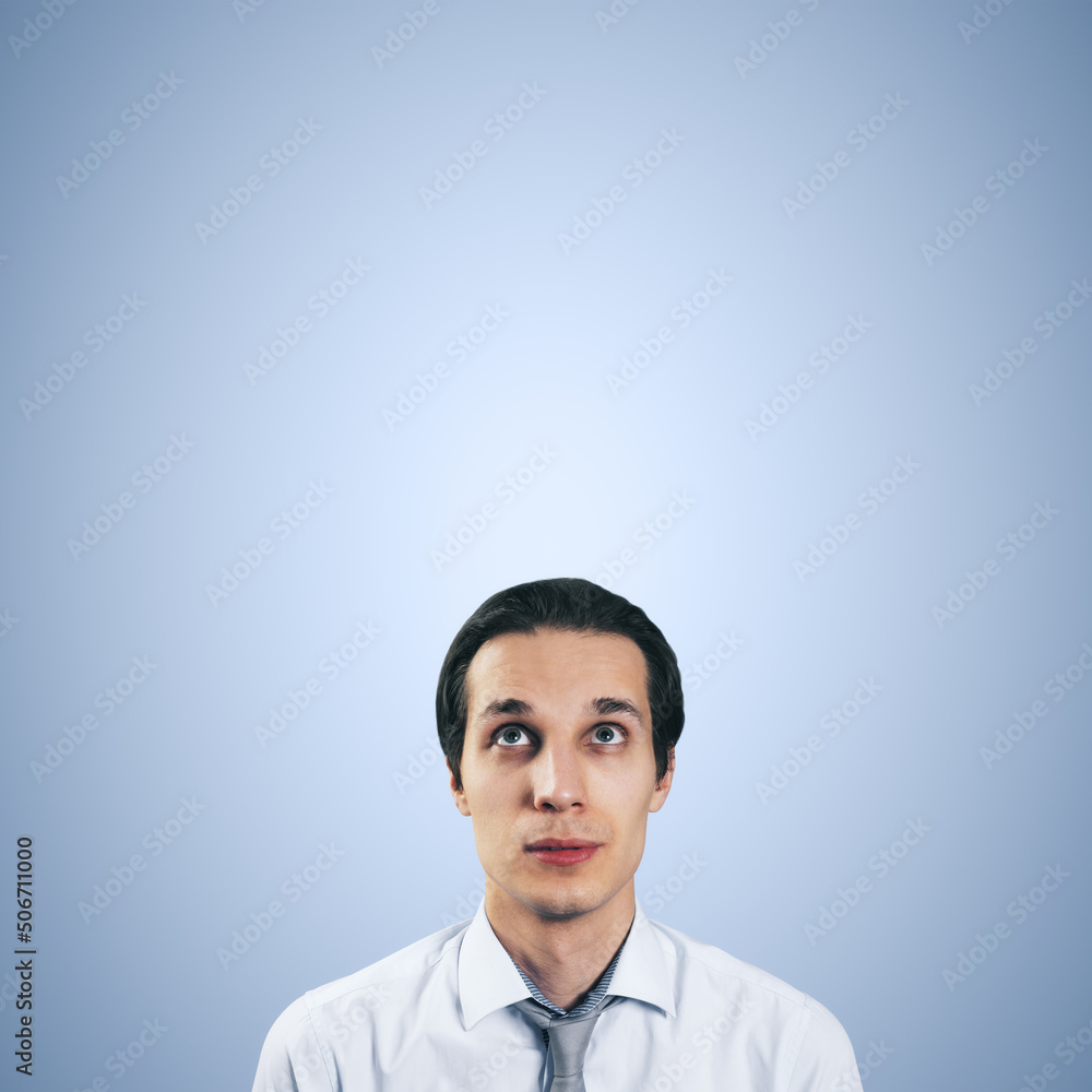 Poster man looking up in white shirt and tie isolated on blank light blue background with empty space for y