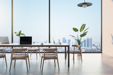 Front view on elegant eco style conference wooden table with laptops, surrounded wooden chairs in sunny room with glossy concrete floor and green plant near glass wall with skyline view. 3D rendering