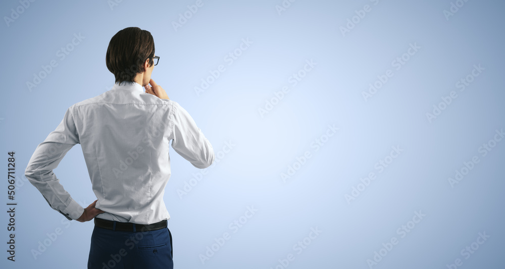 Poster thinking concept with pensive man in white shirt standing on abstract light blue wall backdrop, with