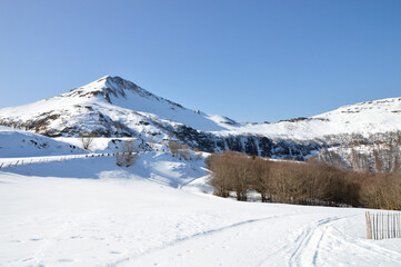 Beautiful snowy mountain landscape, during winter, with a volcanic mountain.	
