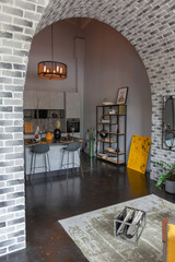 modern luxury design of a brutal apartment interior with arches in the style of a medieval castle with bright accents. a stylish gray kitchen area with an island for cooking or spending time