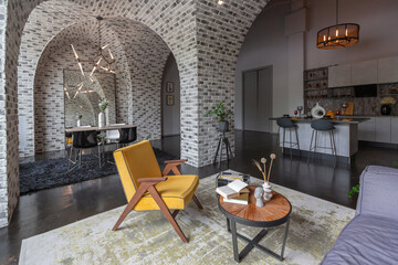 Naklejka premium modern luxury design of a brutal apartment interior with arches in the style of a medieval castle with bright accents. free layout, kitchen area, seating and eating area.