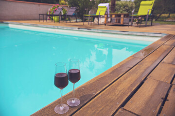 Two glasses of red wine near the swimming pool, chill out area near swimming pool, summer...