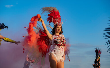 Group of samba dancers with smoke bombs, party outdoors 